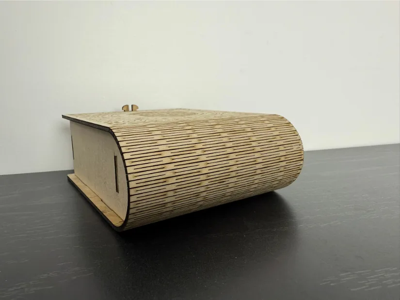 A wooden box featuring an intricately laser-engraved moon within a circular pattern accented by stars, paired with a flexible living hinge for smooth opening. Title for Metadata and Gallery: Moon Engraved Wooden Box with Living Hinge Caption Suggestion: Intricately engraved wooden box with a moon design and a smooth living hinge. 