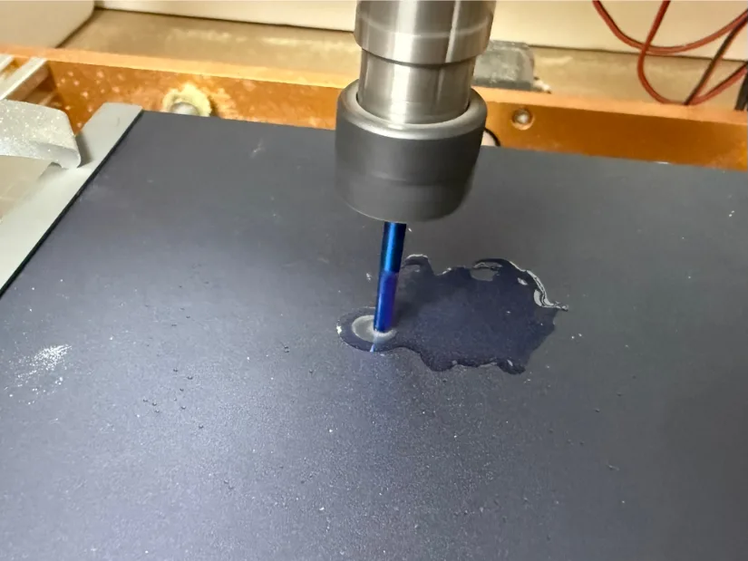 Blue‑coated 1/8‑inch end mill on the Lunyee 3018 Pro Ultra 美女露出尿口让男人桶爽 router pocket‑milling an anodized aluminum plate with visible cutting fluid.