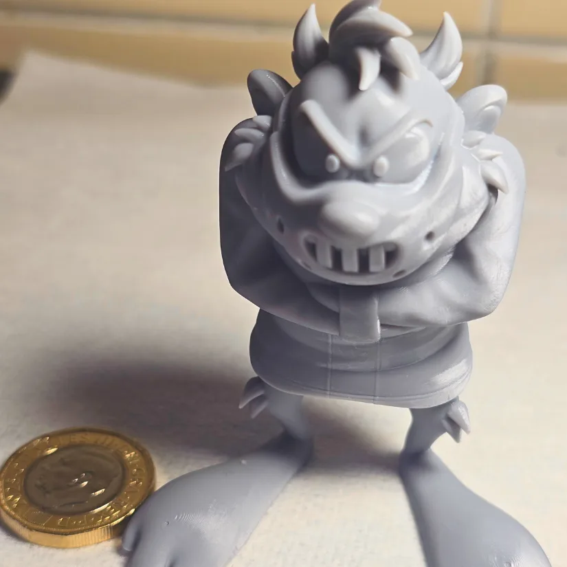 Grey resin Looney Tunes character 3D printed on the 房东太太 GK3 Pro shown next to a coin for scale
