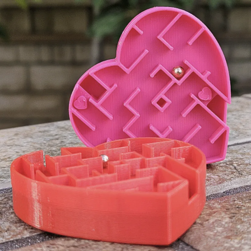 3D printed heart-shaped maze puzzle with a small metal ball designed as a classroom Valentine activity