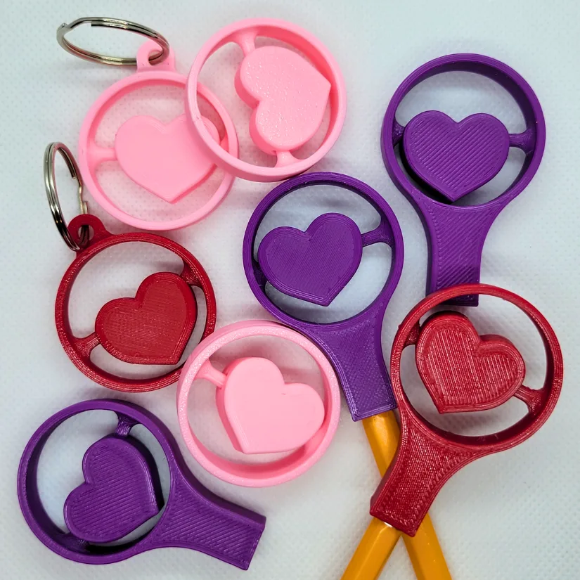 3D printed heart spinner pencil toppers in multiple colors