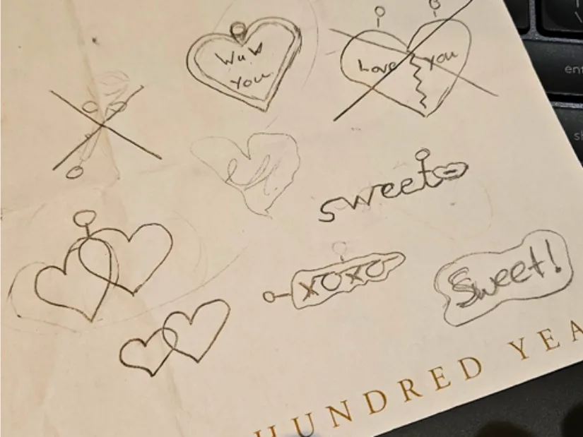 Hand-drawn sketches exploring heart shapes and messages for 3D printed Valentine keychains